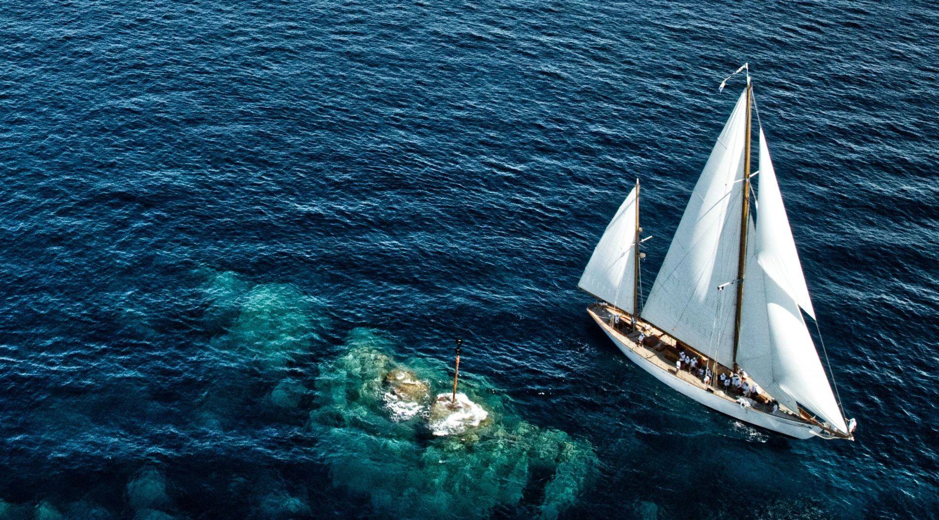 Belle Aventure vu du ciel, toutes voiles dehors au-dessus des fonds turquoise