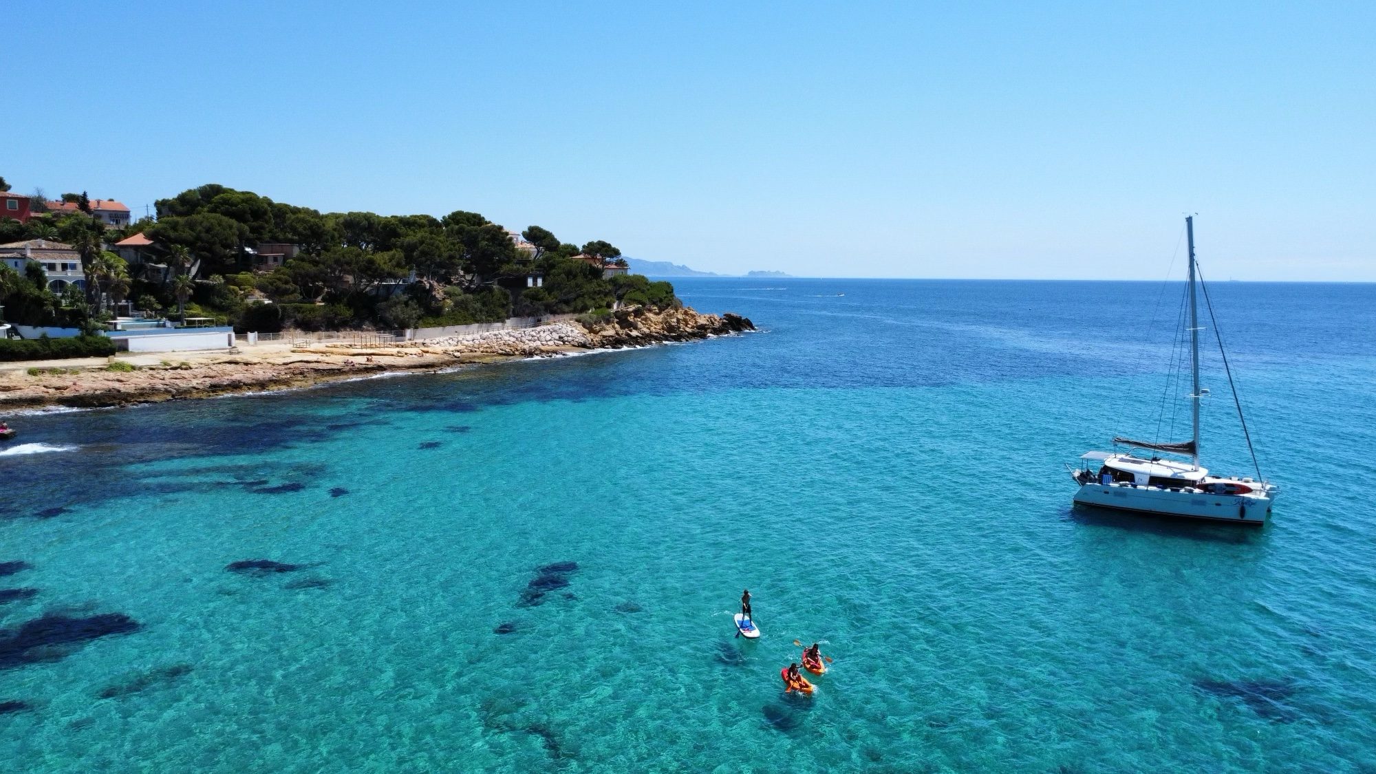 Paddle et kayaks autour d'un catamaran au mouillage sur la Côte Bleue