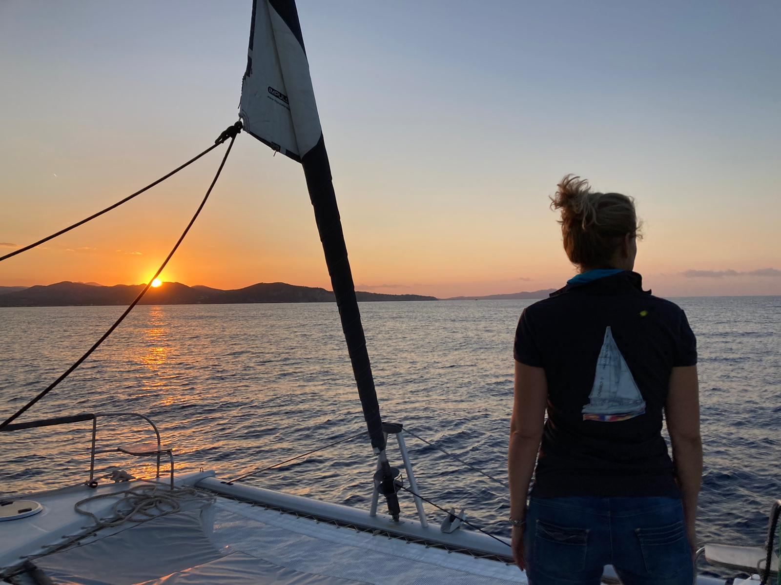 Coucher de soleil sur le trampoline d'un catamaran avec équipage