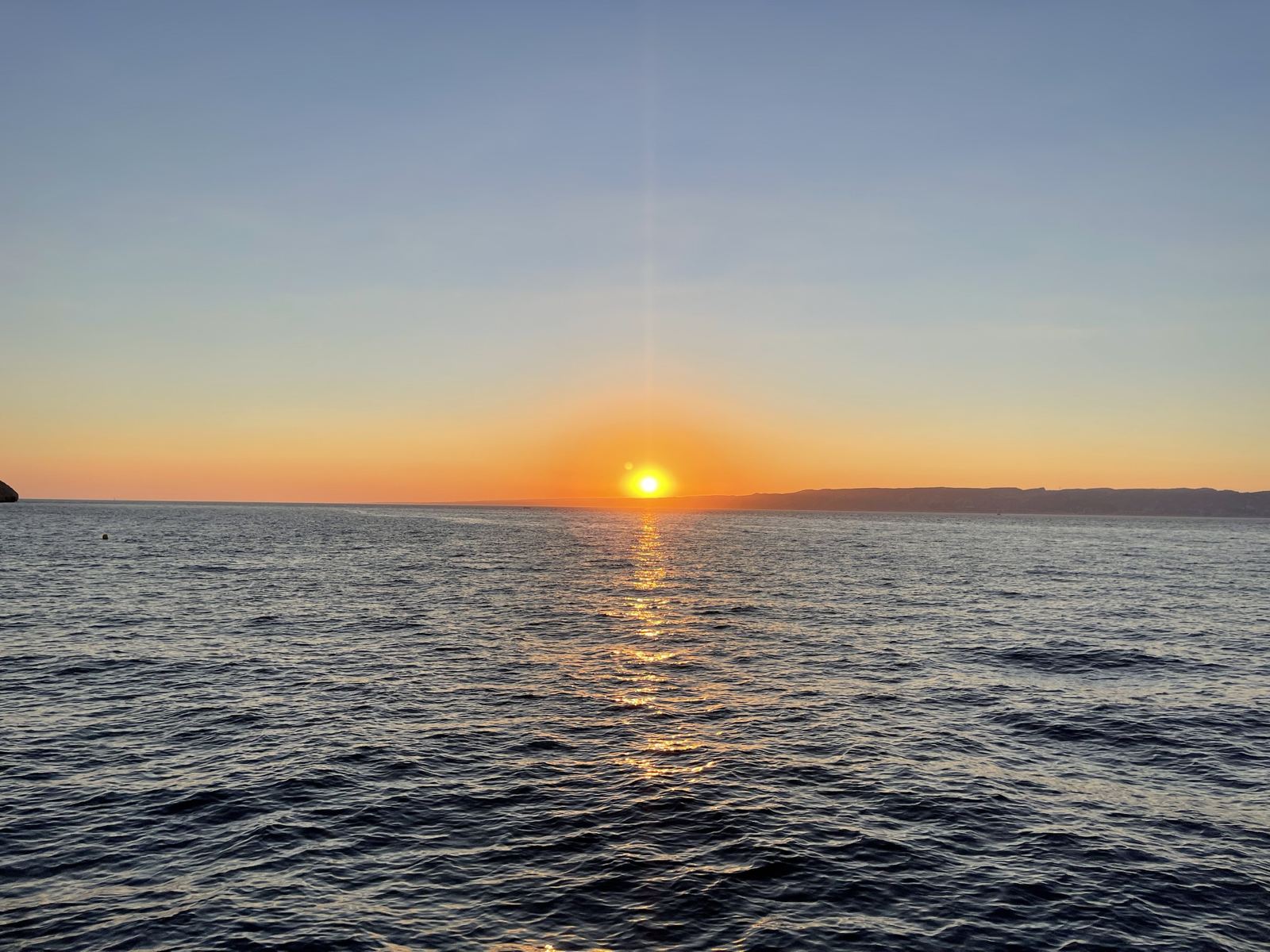 Soleil couchant sur la rade de Marseille lors d'une soirée en mer
